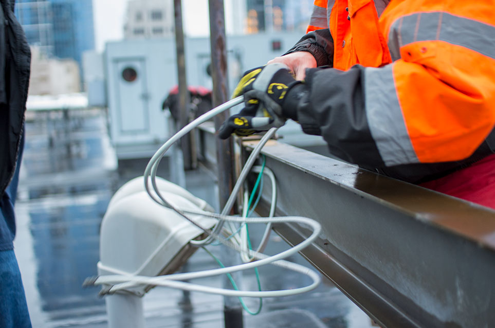 Field Technician working with wire on a rooftop