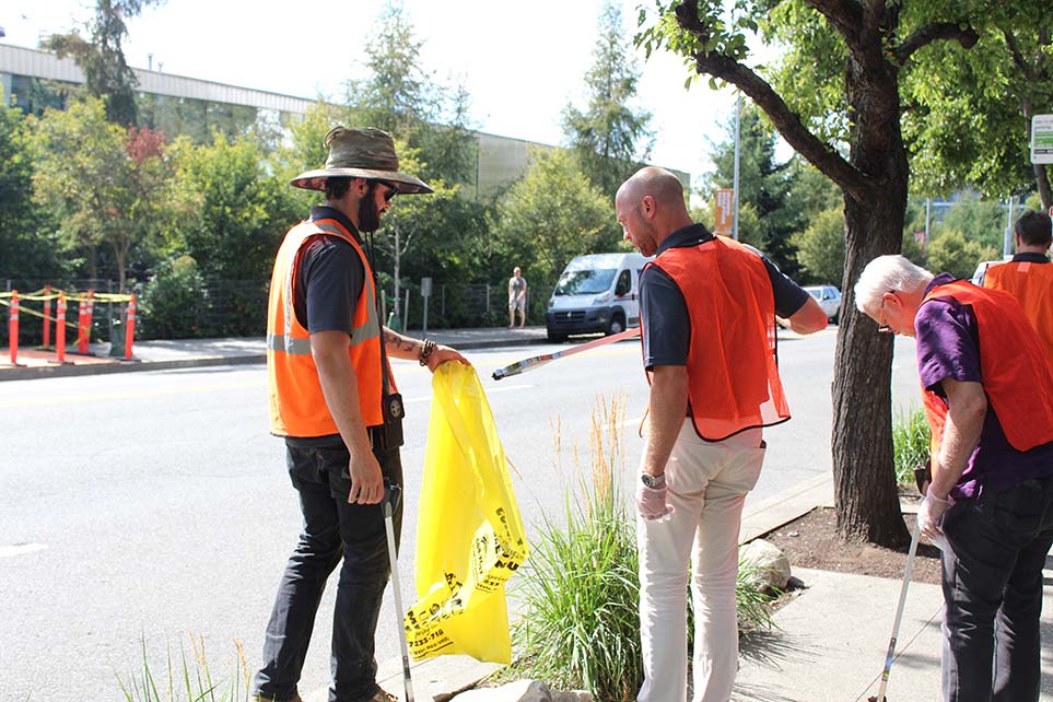 Atlas Employees helping each other pick up trash from the street